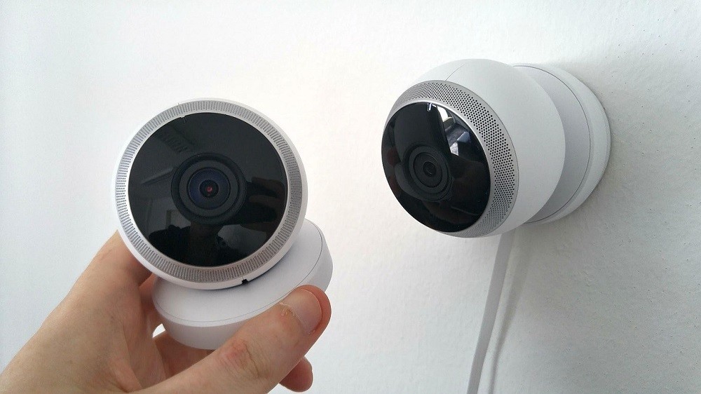 Two home security cameras on a wall