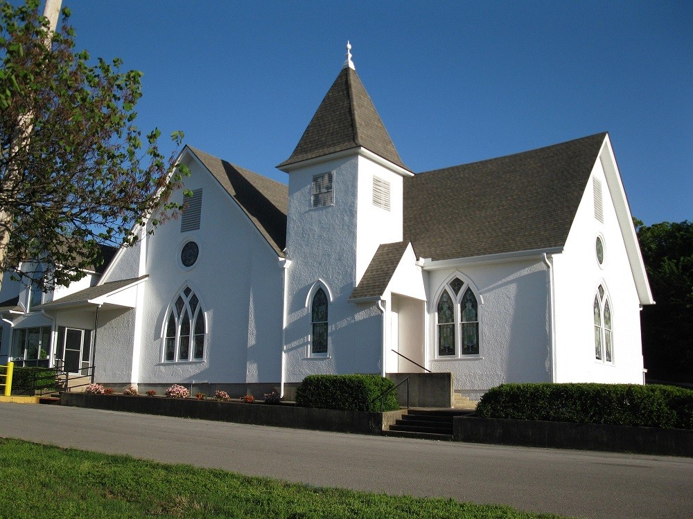 Exterior view of a white church with a grey roof