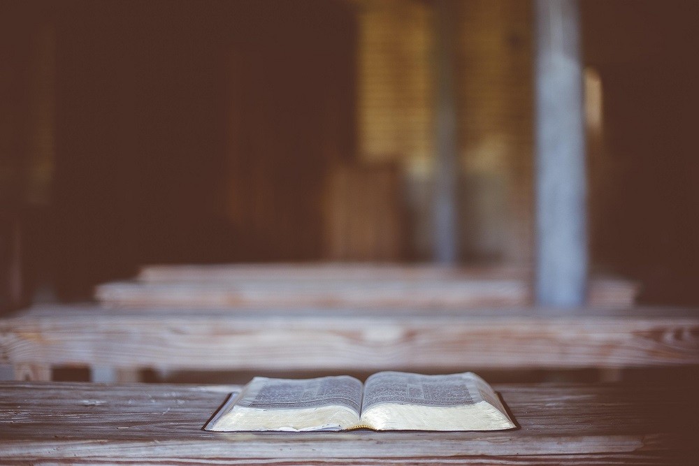 An open bible on a wooden table