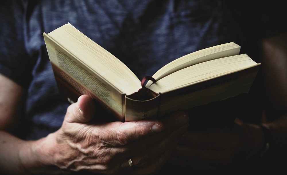 A man reads a book. Even reading can help you build strong character