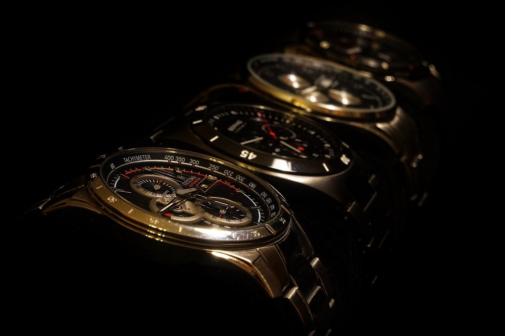 Four watches sit side by side, each with different features including date windows, chronographs, a moonphase, and other timing increments used for measuring time like tachymeters