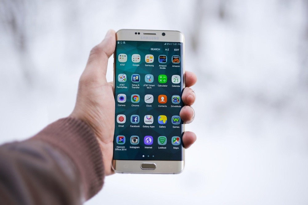 A smartphone with various apps shown on the screen