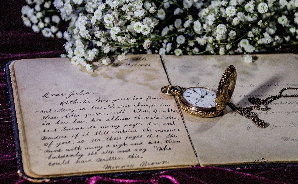 A pocket watch sits open beside a hand written love note